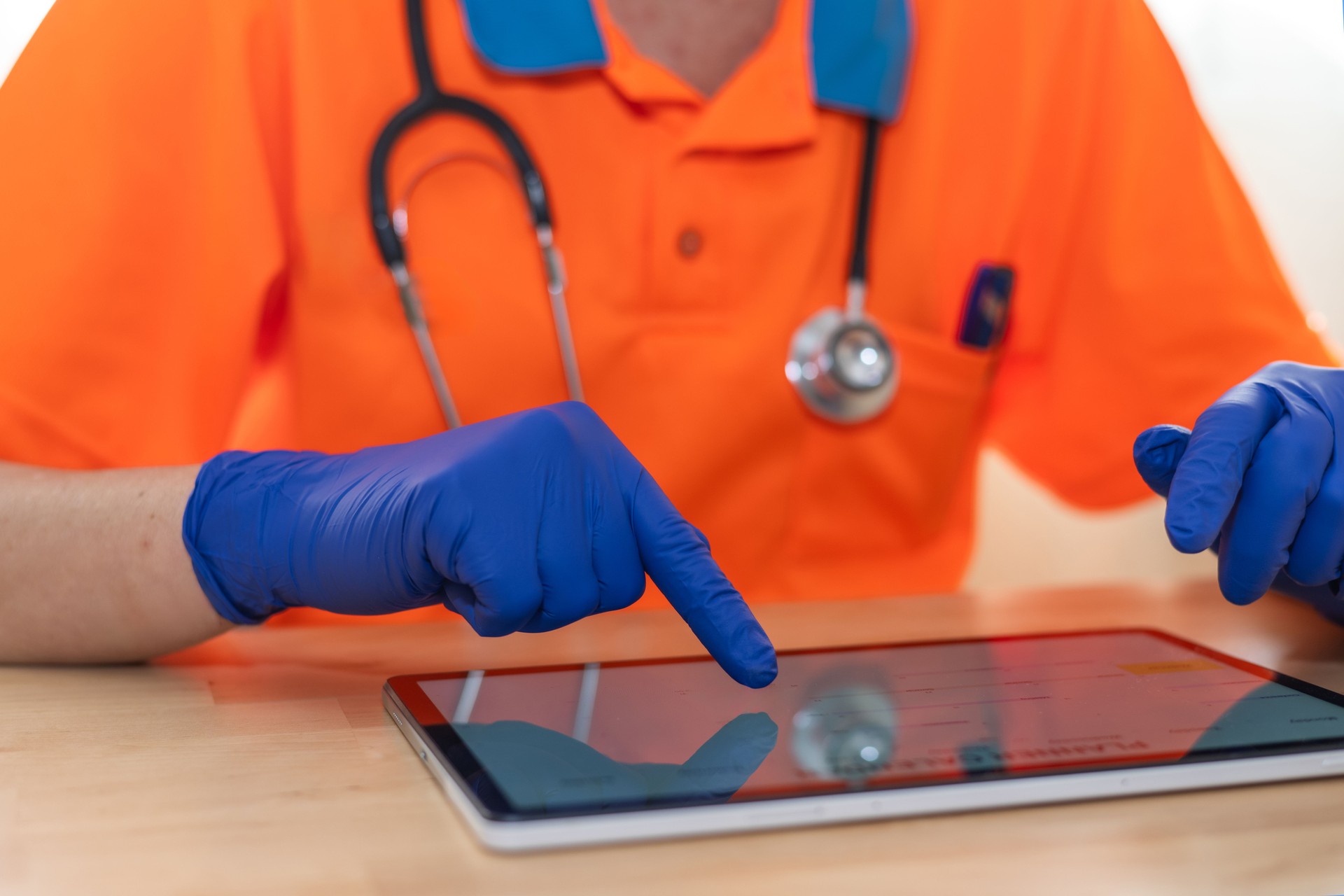 Les ambulanciers paramédicaux portant des gants bleus utilisent une tablette numérique, accédant potentiellement aux informations des patients, aux dossiers médicaux ou aux outils de diagnostic, soulignant l’intégration de la technologie dans les so
